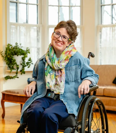 young lady in a wheelchair, smiling. 